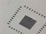 Figure 4. Stencil is turned over while still holding the LGA in place and manually printing with solder paste. 